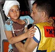 رجل اسعاف اسرائيلي يحمل طفلا مصابا